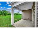 Covered patio with large column and views of spacious green backyard at 572 Woodland Farms Circle, Aynor, SC 29511