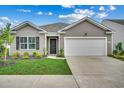 Single-story house with vinyl siding, a two-car garage, and a well-manicured lawn at 572 Woodland Farms Circle, Aynor, SC 29511