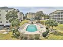 Aerial view of a community pool with sun loungers, spa, and manicured landscaping at 601 Hillside Dr. N # 1405, North Myrtle Beach, SC 29582