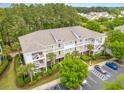 Beautiful condo building with lush landscaping, exterior staircases, ample parking, and palm tree landscaping at 6253 Catalina Dr. # 131, North Myrtle Beach, SC 29582