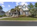 Charming brick home with dark shutters, palm trees, and a well-kept lawn, radiating curb appeal at 63 Grey Moss Rd., Murrells Inlet, SC 29576