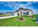 Manicured lawn featuring a charming single-story home with classic curb appeal on a sunny day at 777 Woodland Farms Circle, Aynor, SC 29511