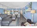 Spacious living room with modern decor, wood floors, a large television, and comfortable seating at 9820 Queensway Blvd. # 704, Myrtle Beach, SC 29572
