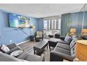Inviting living room with balcony access, comfortable seating, and a flat-screen TV at 9820 Queensway Blvd. # 704, Myrtle Beach, SC 29572