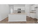 The open-concept kitchen features a granite-topped island and plenty of storage in the white cabinets at 1047 Sentinel Ct., Little River, SC 29566