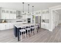 Modern kitchen features white cabinets, stainless steel appliances, an island with seating, and elegant pendant lighting at 1071 Milford Way, Myrtle Beach, SC 29588