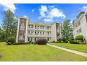 Building 21 with multiple balconies framed by manicured landscaping and the building beside it at 1204 River Oak Dr. # 25-A, Myrtle Beach, SC 29579