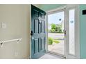 Inviting entryway with green door, neutral walls, and transom window featuring an exterior view and flood of natural light at 130 Scotch Broom Dr. # H-103, Little River, SC 29566
