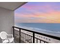 This balcony shows a gorgeous scenic view of the beach at sunset with patio furniture on the balcony at 1501 S Ocean Blvd. # 1044, Myrtle Beach, SC 29577