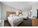 Bright bedroom featuring two beds, a flat-screen TV, and access to a balcony with an ocean view at 1501 S Ocean Blvd. # 1239, Myrtle Beach, SC 29577