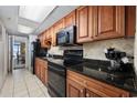 Well-equipped kitchen with sleek black appliances, cherry cabinets, and elegant black granite countertops at 1501 S Ocean Blvd. # 1239, Myrtle Beach, SC 29577