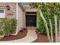 Close-up of the double front door with brick facade, lush landscaping, and walkway at 1504 Sedgefield Dr., Murrells Inlet, SC 29576