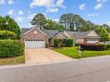 Attractive brick home featuring an attached two-car garage, manicured landscaping, and a welcoming driveway at 1504 Sedgefield Dr., Murrells Inlet, SC 29576