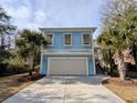 Charming blue home with well manicured lawn featuring palm trees, enhancing the curb appeal of the property at 18 Trigger Fish Ln., Murrells Inlet, SC 29576