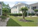 A well-maintained backyard with a manicured lawn, lush trees, and a BBQ grill, offering a serene outdoor space at 22 Woodhaven Dr. # C, Murrells Inlet, SC 29576