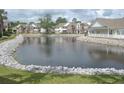 A tranquil pond surrounded by rock landscaping, showcasing a picturesque waterfront view of the community at 22 Woodhaven Dr. # C, Murrells Inlet, SC 29576