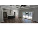 Open-concept space with wood-look floors that connects the living room to the kitchen and glass doors at 25 Pinewood Dr., Carolina Shores, SC 28467