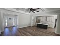 An open-concept living room that connects to the kitchen with wood-look floors and neutral walls at 25 Pinewood Dr., Carolina Shores, SC 28467