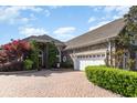 Charming brick home featuring a paver driveway leading to an attached garage at 276 Waterfall Circle, Little River, SC 29566