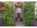 Inviting red front door framed by lush greenery and brick archway at 276 Waterfall Circle, Little River, SC 29566