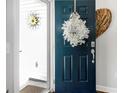A view of the front door adorned with a white floral wreath with welcome sign at 3024 Calusa Dr., Little River, SC 29566