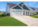 Single-story home with a two-car garage, manicured lawn, and a welcoming front entrance under a clear blue sky at 3024 Calusa Dr., Little River, SC 29566