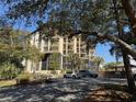 Multi-story condominium with balconies, screened in porches, and a parking area beneath shady trees at 310 N 73Rd Ave. N # 5D, Myrtle Beach, SC 29572
