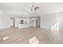 Open-concept living room with wood floors leading to kitchen with island and stainless appliances at 3324 Little Bay Dr., Conway, SC 29526