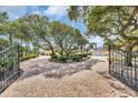 Estate entrance featuring a circular drive, mature trees, and wrought iron gates at 4204 N Ocean Blvd., Myrtle Beach, SC 29577