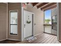 Condo entrance with a white door decorated with a wreath, and a view of the outdoor landscape from the balcony at 4500 S Ocean Blvd. # 4, North Myrtle Beach, SC 29582