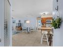 Open-concept living room and kitchen area with tiled floors, light blue walls, and modern furnishings at 4500 S Ocean Blvd. # 4, North Myrtle Beach, SC 29582