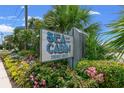 Close up of the Sea Cabin Cherry Grove sign surrounded by lush plants and flowers on a sunny day at 6001 N Ocean Blvd. # 147, North Myrtle Beach, SC 29582