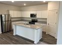 Modern kitchen with white cabinets, granite countertops, stainless steel appliances, and a center island at 624 Muster Field Ct., Conway, SC 29526