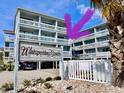 Charming low-rise condo complex with a welcoming sign, lovely balconies, and well-maintained landscaping at 627 N Waccamaw Dr. # 203, Murrells Inlet, SC 29576