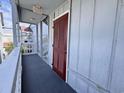 Exterior hallway with shingled walls leads to the front door of the condominium at 627 N Waccamaw Dr. # 203, Murrells Inlet, SC 29576