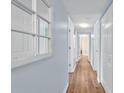 Bright hallway featuring wood floors, crisp white trim, and neutral blue wall creating a welcoming space at 8570 Hopkins Circle # D, Surfside Beach, SC 29575