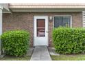 Close-up of front door #33, surrounded by lush green bushes and a well-maintained brick facade for added curb appeal at 86 Beaver Pond Loop # 33, Pawleys Island, SC 29585