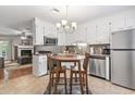 Bright kitchen featuring white cabinetry, stainless steel appliances, a cozy breakfast nook, and access to the living room at 86 Beaver Pond Loop # 33, Pawleys Island, SC 29585