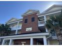 Close up of The Villas 100, building exterior with brick and covered parking at 1000 Ray Costin Way # 114, Murrells Inlet, SC 29576