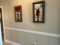 Neutral hallway featuring two pieces of art and trim at 1000 Ray Costin Way # 114, Murrells Inlet, SC 29576