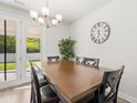 Inviting dining room features a stylish chandelier, wooden table, and access to the backyard at 1087 Baker Creek Loop, Myrtle Beach, SC 29579