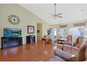 Comfortable living room features wood flooring, vaulted ceiling, ceiling fan, and a large screen TV at 1250 Camlet Ln., Little River, SC 29566