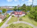 Stunning aerial view of a waterfront home featuring a red roof and lush landscaping at 128 Causey St., Myrtle Beach, SC 29577