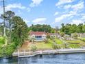 Picturesque waterfront property with a private dock, swimming pool, and manicured lawn at 128 Causey St., Myrtle Beach, SC 29577
