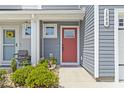 Inviting front door with a vibrant red color and a charming welcome mat and well-maintained landscaping at 136 Villa Grande St. # B, Myrtle Beach, SC 29579