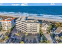 Aerial view of oceanfront condo with balconies, and a parking lot at 1581 S Waccamaw Dr. # 302, Garden City Beach, SC 29576