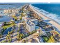 Aerial view of coastal condo complex, ocean, beach, and residential neighborhood at 1581 S Waccamaw Dr. # 302, Garden City Beach, SC 29576