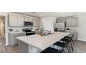 Modern kitchen featuring an island with bar stool seating, stainless steel appliances, and grey cabinetry at 177 Ashworth Dr., Tabor City, NC 28463