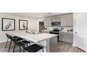 Stylish kitchen featuring an island with seating, stainless appliances, and light grey cabinets at 177 Ashworth Dr., Tabor City, NC 28463