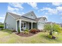 Well-maintained home featuring manicured landscaping, a covered porch, and a driveway leading to a two-car garage at 1827 Parish Way, Myrtle Beach, SC 29577